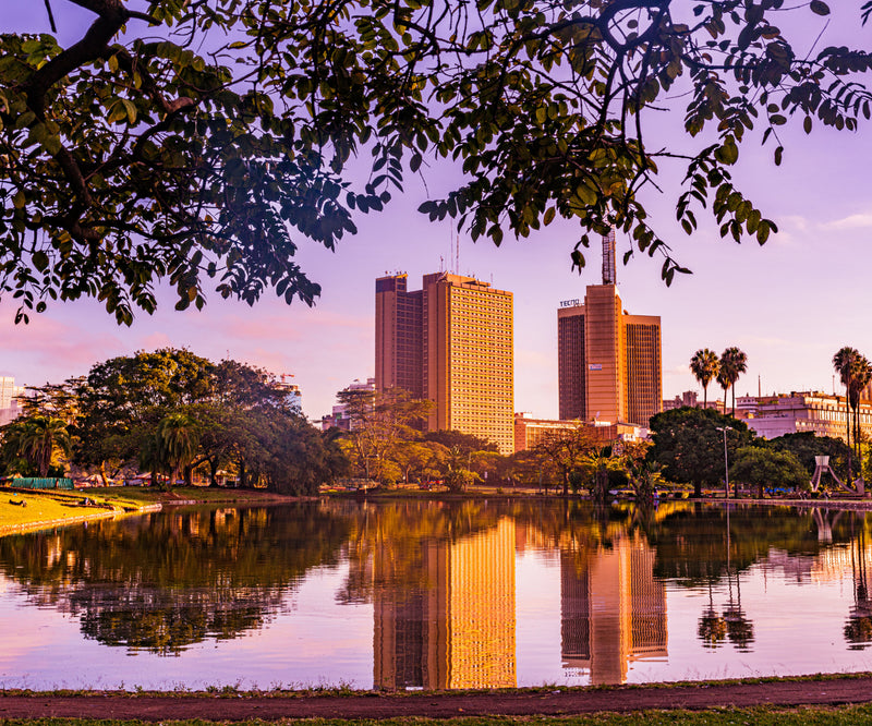 A city skyline reflected in a lake at sunset, showing the urban side of Kenya.